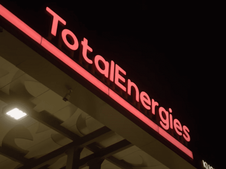TotalEnergies logo in neon lights on a petrol station.